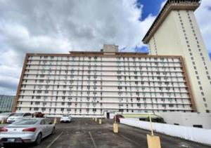 un grand bâtiment blanc avec des voitures garées dans un parking dans l'établissement Apt in San Juan, 4 guests max, 1 BR-1 BTH, Full kitchen, Free Internet-Parking, à San Juan