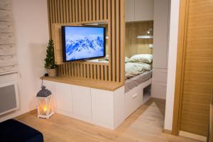 ein Wohnzimmer mit einem TV im Schlafzimmer in der Unterkunft Nomad Jahorina in Jahorina