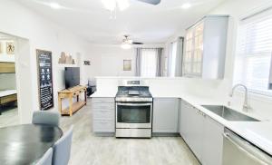 a white kitchen with a stove and a sink at Vacation Home Minutes From Downtown, Great For Families in Ogden