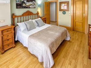 1 dormitorio con 1 cama grande y vestidor de madera en Hostal Real Aranjuez, en Aranjuez