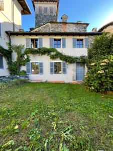 a large white house with a grass yard at L&B HOUSE in Orta San Giulio