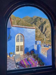 a view through a window of a blue building at Casa Sanae in Chefchaouene