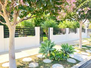 una valla blanca con árboles y plantas en un patio en NoHo Luxury Oasis I saltwater pool-spa I sleeps up to 8 I 15 mins from Hollywood en Los Ángeles