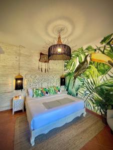 1 dormitorio con 1 cama grande y un mural tropical en Castillo Tulum en Tulum