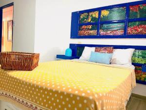 een slaapkamer met een bed met een schilderij aan de muur bij Acogedor y tranquilo in Santo Domingo