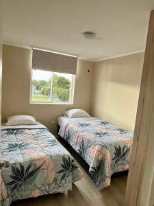 a bedroom with two beds and a window at Brisas del sur in Osorno