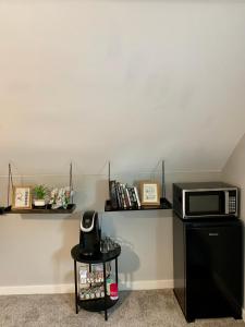 a microwave sitting on top of a black refrigerator at A Cozy Place to Land in Salem