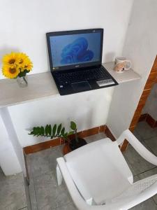 un ordenador portátil sentado en un estante junto a una silla en Estudio en Garzota con Cocina y lavanderia Wifi, en Guayaquil