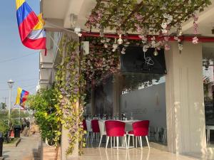 una mesa con sillas rojas frente a un edificio con flores en Estudio en Garzota con Cocina y lavanderia Wifi, en Guayaquil