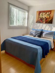 a bedroom with a bed with blue sheets and a window at 3 Quartos Melhor Valor do Df próximo ao Aeroporto e Plano in Brasilia