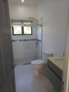 La salle de bains blanche est pourvue de toilettes et d'une fenêtre. dans l'établissement The Willow Apartment, à Clifton Falls