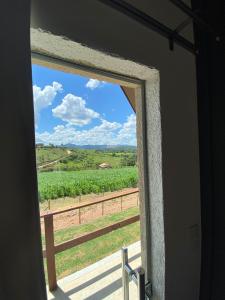a window in a room with a view of a vineyard at Chalezinho Pousada in Brumadinho