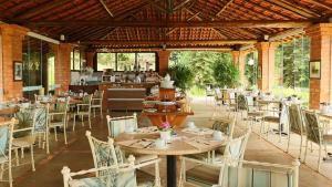 a restaurant with tables and chairs in a pavilion at Pousada Vale do Dinossauro in São Pedro