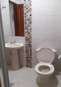 een badkamer met een toilet en een wastafel bij Hotel PaloQuemao in Quibdó