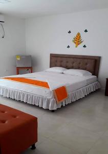 een slaapkamer met een groot bed met een houten hoofdeinde bij Hotel PaloQuemao in Quibdó