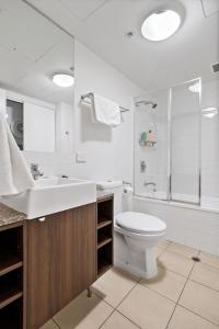 a bathroom with a toilet and a sink and a shower at Brisbane Break Panoramic River Views Free Parking in Brisbane