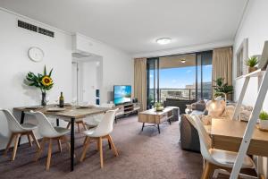 a living room with a table and a couch at Brisbane Break Panoramic River Views Free Parking in Brisbane