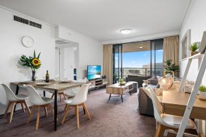 ブリスベンにあるBrisbane Break Panoramic River Views Free Parkingのテーブルとソファのあるリビングルーム