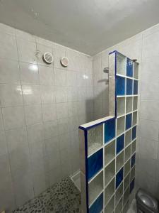 a bathroom with a shower with blue and white tiles at Studio « Ti Thon » avec vu magnifique sur la Montagne du Vauclin in Le Vauclin