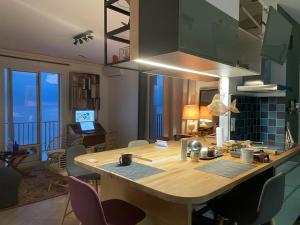 a kitchen with a large wooden table and chairs at Une grande terrasse sur la mer in Brando