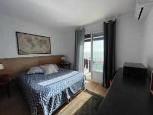 Une grande terrasse sur la mer في Brando: غرفة نوم مع سرير وإطلالة على المحيط