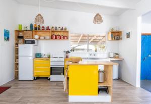 een keuken met gele kasten en een geel eiland bij The Piccolo Shack in Gracetown