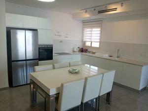 a kitchen with a table and a refrigerator at King David breathtaking LAKE VIEW 4BDR PENTHOUSE in Tiberias