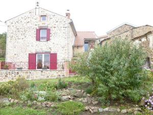 une maison en pierre avec des volets rouges et une cour dans l'établissement Gîte Saint-Just-prés-Brioude, 4 pièces, 6 personnes - FR-1-582-231, à Saint-Just-près-Brioude