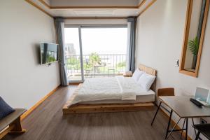 a bedroom with a bed and a large window at Jeju the sky and the earth in Jeju