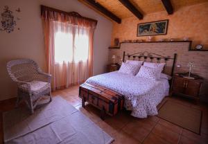 a bedroom with a bed and a chair and a window at VIVENCIAS casa rural para 10 personas in Camuñas