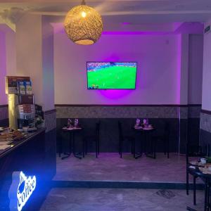 um bar com bancos e uma televisão na parede em AFRIC HOTEL- Casbah em Alger