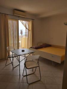 a room with a table and chairs and a bed at Tres Caravelas Studio Flats in Santa Maria
