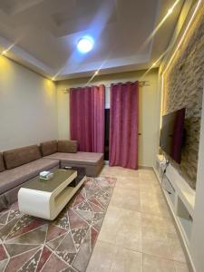 salon z kanapą i telewizorem w obiekcie sunny lakes , pool view apartment in down town w Szarm el-Szejk