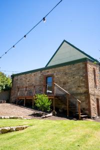 a brick building with a porch and a deck at Adelaide Hills Luxury Escape - 1884 Summertown in Summertown