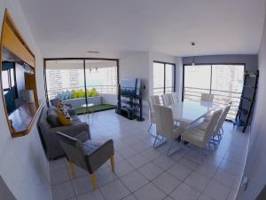 een eetkamer en een woonkamer met een tafel en stoelen bij DEPTO SUITE II in Iquique