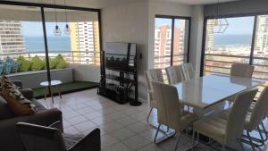 a living room with a table and chairs and a television at DEPTO SUITE II in Iquique +13 photos