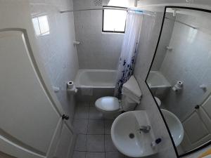 Baño blanco con aseo y lavamanos en DEPTO SUITE II, en Iquique