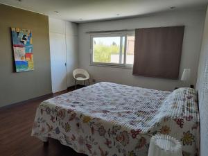 een slaapkamer met een bed met een bloemendeken en een raam bij Casa Diego in Mendoza