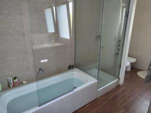 een badkamer met een bad en een glazen douche bij Casa Diego in Mendoza