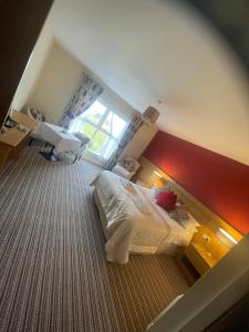 a small bedroom with a bed and a window at The Hedges Hotel in Stranocum