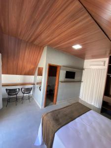 a bedroom with a bed and a table and chairs at Chalezinho Pousada in Brumadinho