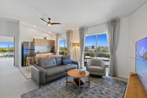 a living room with a couch and a kitchen at Incredible Beachside Penthouse-RIVA11 in Mooloolaba