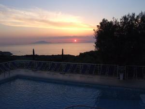 a sunset over the ocean with a swimming pool at Hotel Dania in Sorrento