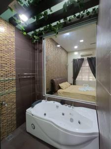 a bathroom with a large mirror and a bath tub at Oro Homestay in Kluang