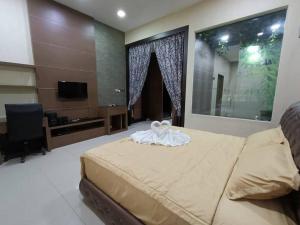 a bedroom with a large bed and a television at Oro Homestay in Kluang