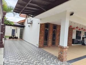 a white house with a courtyard with a patio at Oro Homestay in Kluang