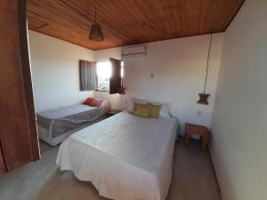 a bedroom with two beds and a wooden ceiling at Casa Vila Verde in Pôrto de Pedras