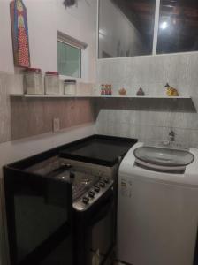 Il comprend une cuisine équipée d'une cuisinière et d'un évier. dans l'établissement Mandakaru Flats De Luxo, à Porto de Galinhas