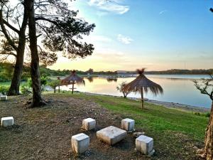 una vista de un cuerpo de agua con árboles y césped en Amanecer en Calamuchita en Embalse