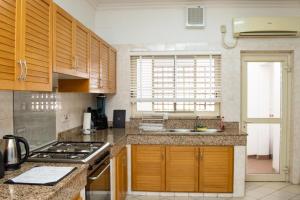 a kitchen with wooden cabinets and a stove top oven at Pier Harbour Residences and Spa in Lagos